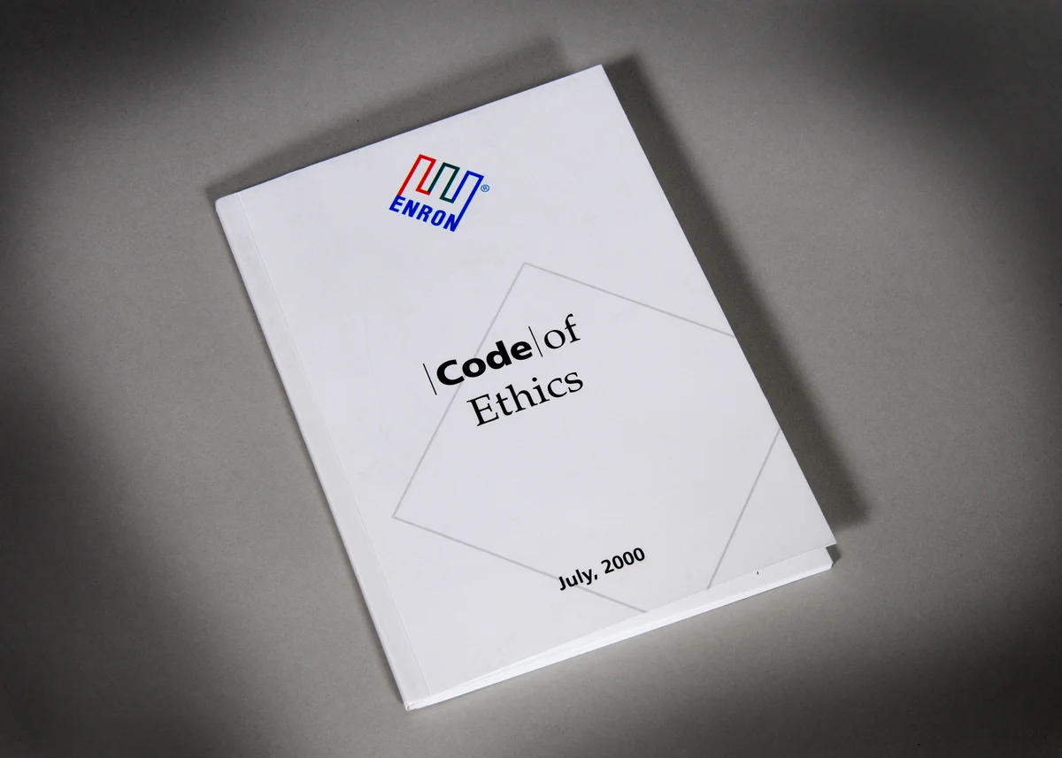 A physical copy of Enron's 64-page Code of Ethics booklet — the ironic symbol of a company whose fraud required the board to formally waive the code twice