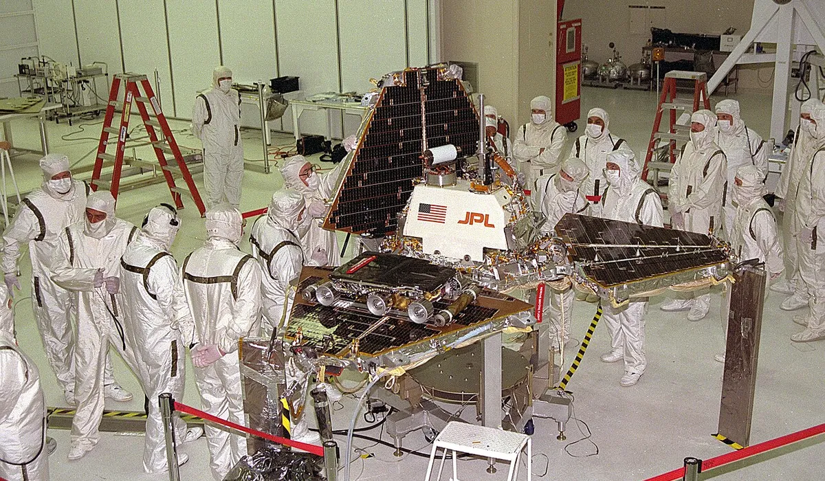 Mars Pathfinder lander being assembled at JPL, showing the tetrahedral airbag landing structure and solar panels