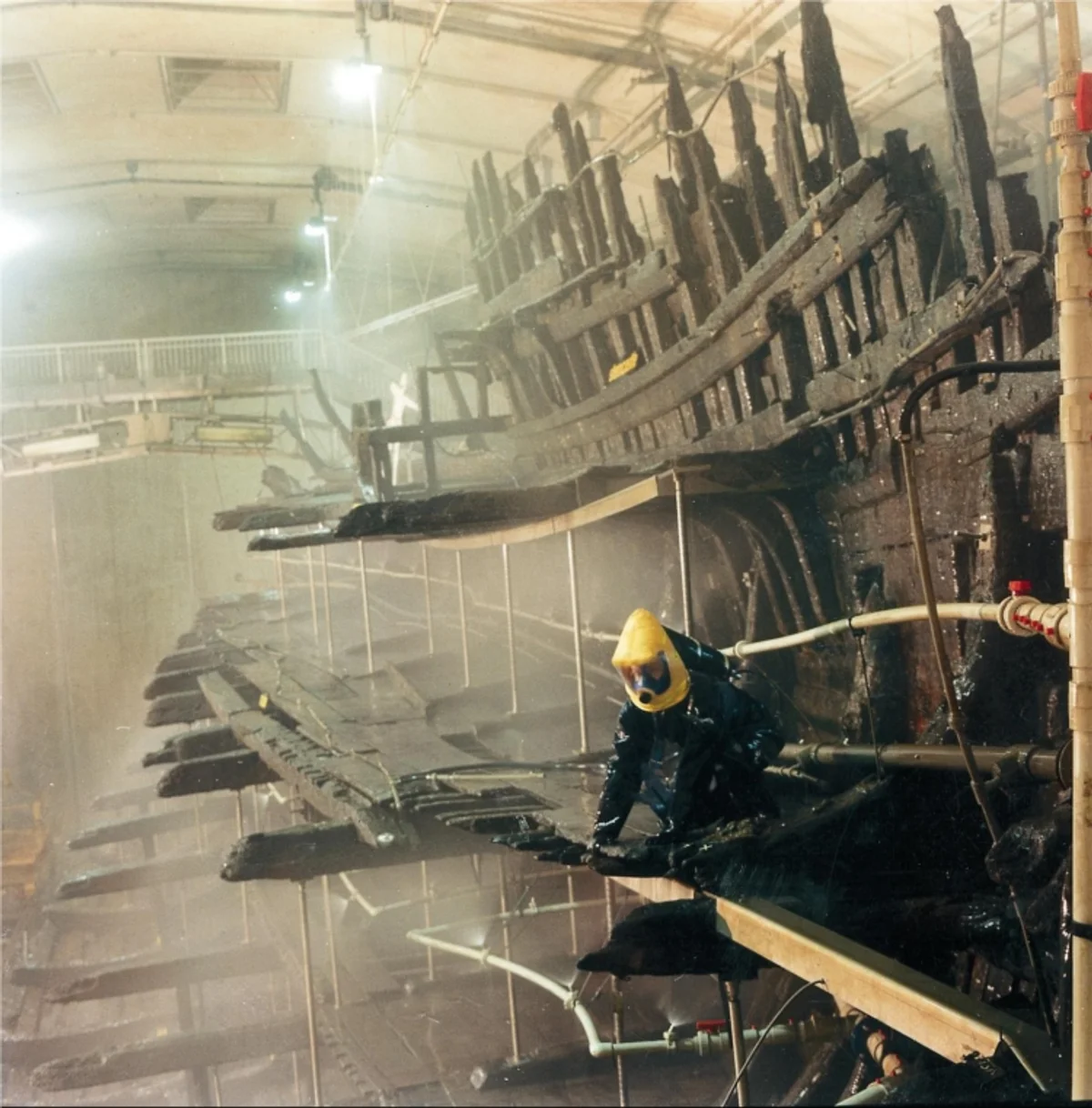 The preserved hull of the Mary Rose in its climate-controlled conservation chamber at the Mary Rose Museum in Portsmouth, showing the surviving starboard side of the Tudor warship raised from the Solent in 1982