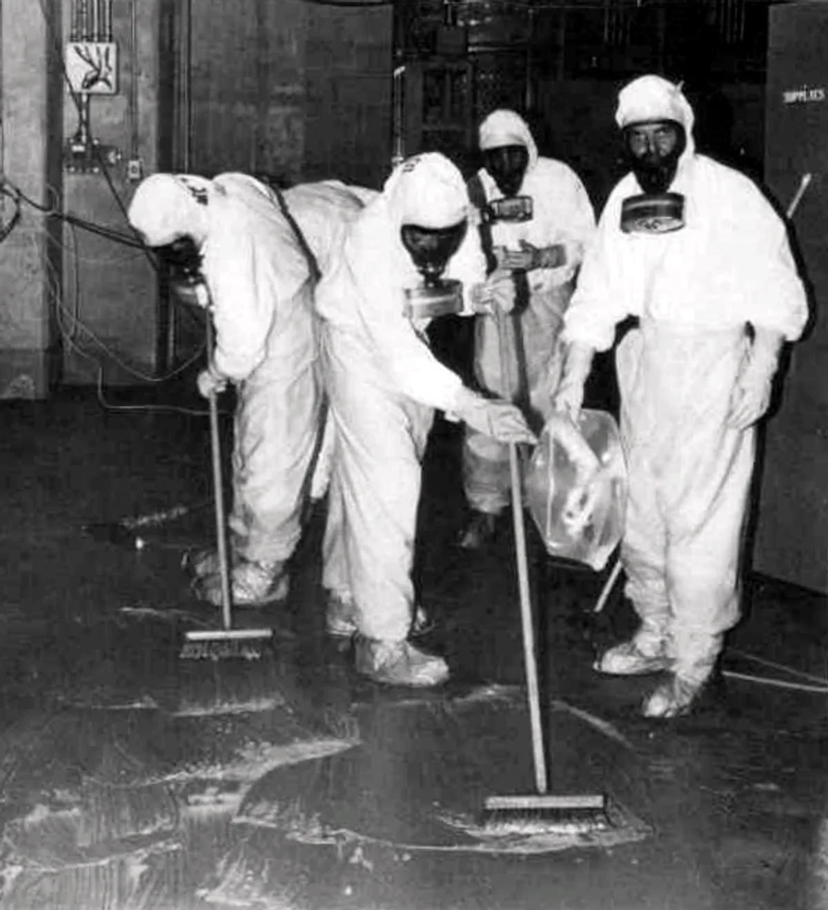 Workers in protective gear conducting cleanup operations inside the Three Mile Island Unit 2 reactor building following the 1979 partial meltdown